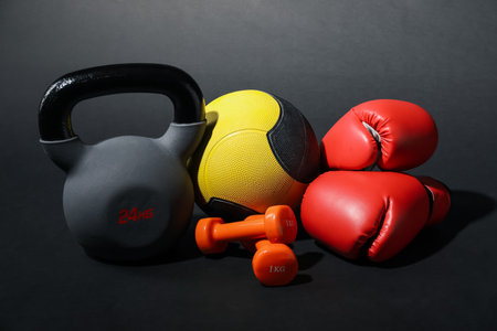 Kettlebell, medicine ball, boxing gloves and dumbbells on black backgroundの写真素材