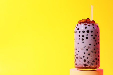 Tasty milk bubble tea in glass on yellow background, space for textの写真素材