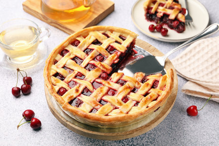 Tasty cherry pie and berries on gray textured table, closeupの写真素材
