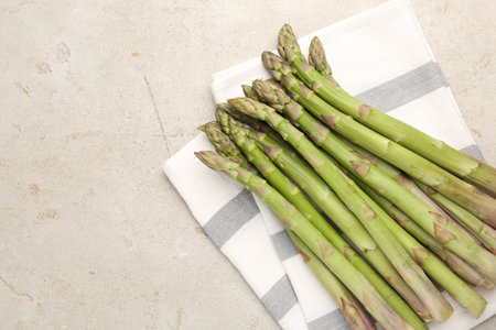 Fresh raw asparagus on light gray table, top view. Space for textの写真素材