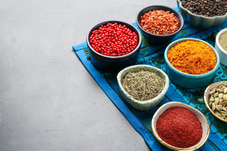 Different aromatic spices on gray table, closeup. Space for text
