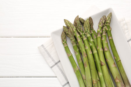 Fresh raw asparagus spears on white wooden table, top view. Space for textの写真素材