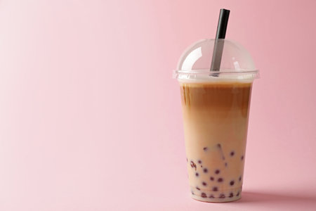 Tasty milk bubble tea in plastic cup on pink background. Space for textの写真素材
