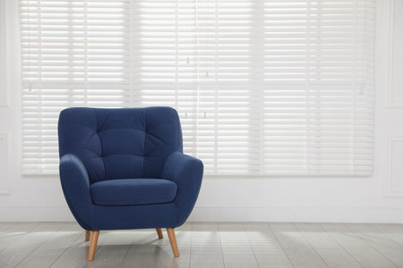 Comfortable blue armchair near white wall indoors, space for textの写真素材