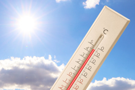 Extremely high temperature on thermometer against blue sky on sunny day. Summer weather