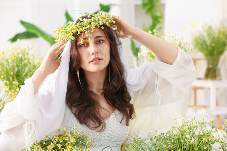 Portrait of beautiful woman with chamomile flowers indoorsの写真素材