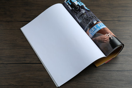 Open magazine on wooden table, above view. Mockup for designの写真素材