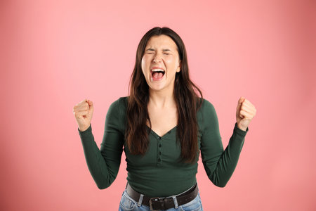 Portrait of emotional woman on pink backgroundの写真素材
