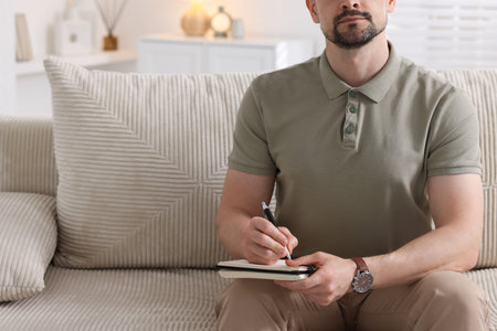 Professional psychologist with notebook on sofa in office, closeupの写真素材