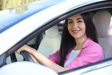 Woman behind steering wheel of modern car, view from outsideの写真素材