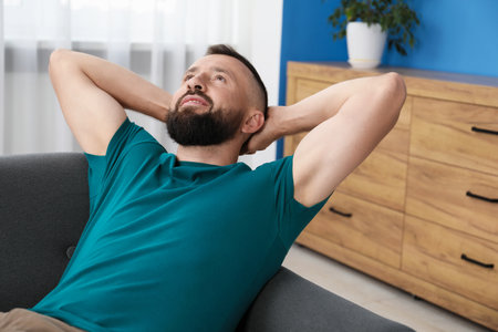Harmony. Man relaxing on comfortable sofa at homeの写真素材