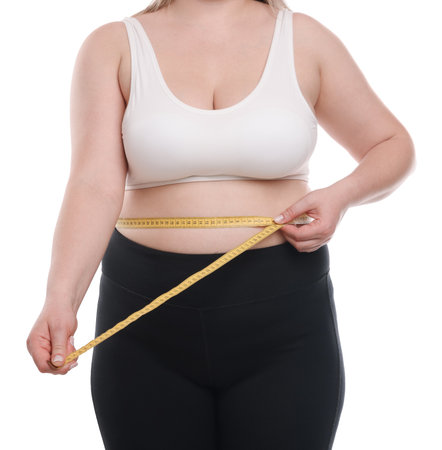 Weight loss. Plus size woman measuring waist with tape on white background, closeupの写真素材