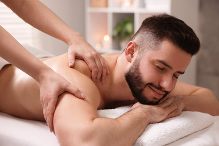 Man receiving relaxing massage in spa salonの写真素材