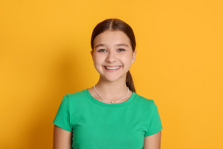 Portrait of teenage girl on orange backgroundの写真素材