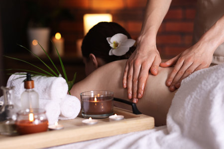 Woman receiving back massage with oil in spa salonの写真素材