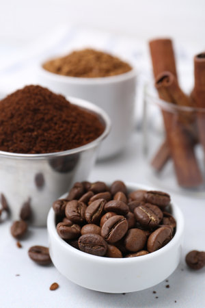 Roasted beans, different types of instant coffee and cinnamon sticks on light table, closeupの写真素材