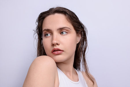 Beautiful woman with natural skin complexion on light grey background, closeupの写真素材