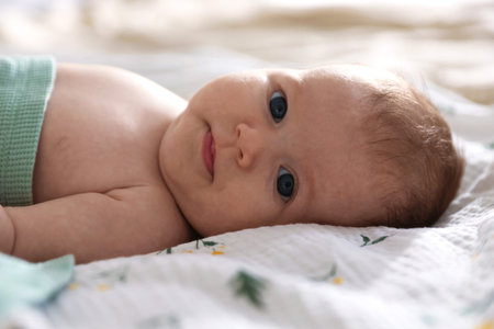 Cute newborn baby lying on bed, closeup