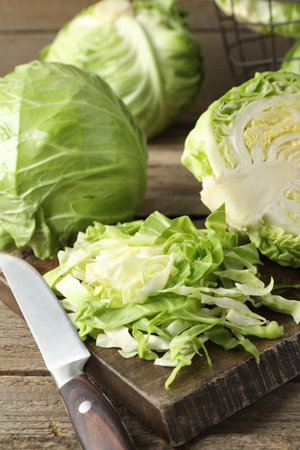 Fresh cabbages and knife on wooden table, closeupの写真素材