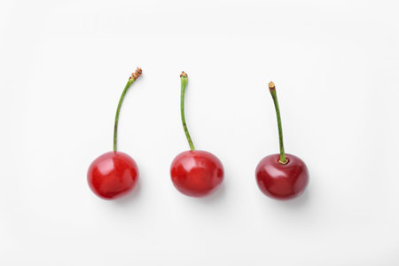 Fresh ripe cherries on white background, flat layの写真素材