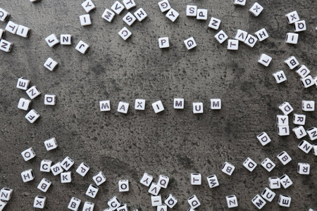 Word Maximum made of cubes on gray table, flat layの写真素材