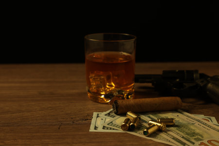 Mafia and criminal world. Gun, bullets, money, cigar and whiskey on wooden table, closeupの写真素材