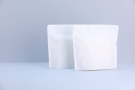 Two zipper stand-up pouches on light gray background. Mockup for design