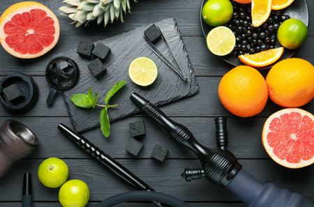 Hookah, coal and fresh fruits on black wooden table, flat layの写真素材