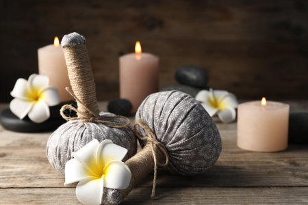 Composition with herbal bags and spa stones on wooden table, closeupの写真素材
