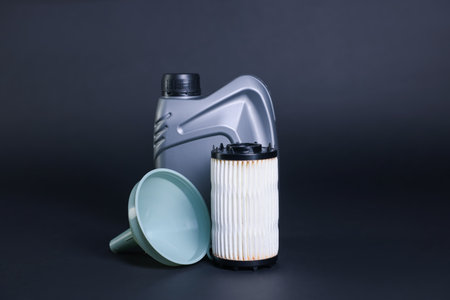 Motor oil in plastic canister, filter and funnel on dark gray backgroundの写真素材