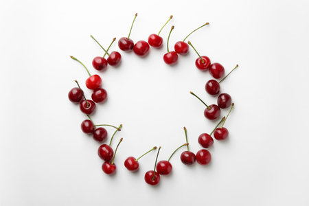 Frame of fresh ripe cherries on white background, flat lay. Space for textの写真素材