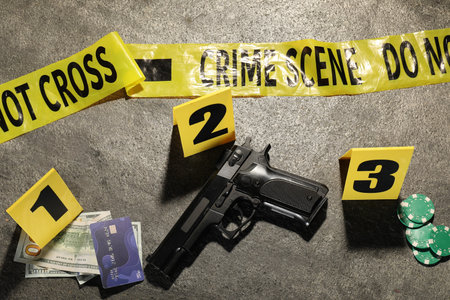 Forensic expertise. Crime scene with evidence, markers and police tape on gray background, flat lay