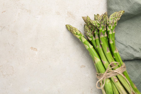 Fresh raw asparagus on light gray table, top view. Space for textの写真素材