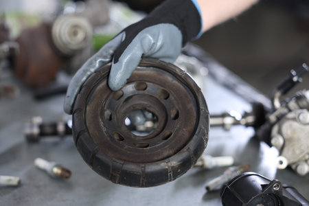 Auto part. Professional mechanic with strut mount at table indoors, closeupの写真素材