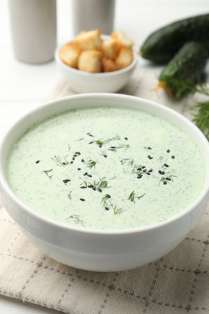 Tasty cucumber soup, croutons and ingredients on white wooden table, closeupの写真素材