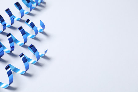 Shiny serpentine streamers on white background, above view. Space for textの写真素材