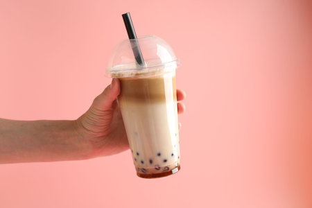 Woman with tasty milk bubble tea on pink background, closeupの写真素材