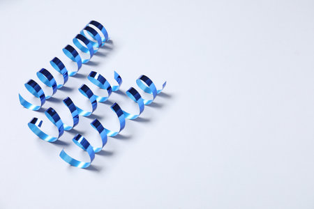 Shiny serpentine streamers on white background, above view. Space for textの写真素材