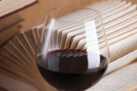 Glass of red wine and open book on table, closeupの写真素材