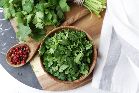Fresh green cilantro and peppercorns on white table, top viewの写真素材