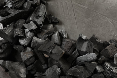 Pieces of black coals on gray table, flat layの写真素材