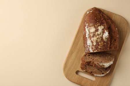 Pieces of fresh rye bread on beige background, top view. Space for text