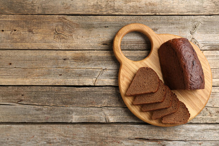 Pieces of fresh rye bread on wooden table, top view. Space for text