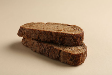 Pieces of fresh rye bread on beige background, closeup
