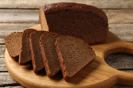 Pieces of fresh rye bread on wooden table, closeup