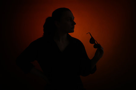 Silhouette of woman with sunglasses on dark gradient background