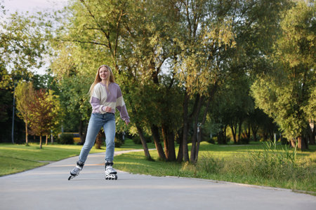 Happy young woman roller skating in park