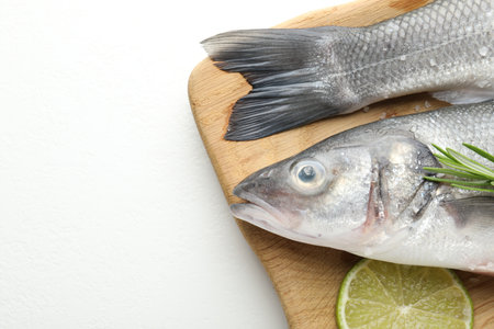 Fresh raw seabass fish with spices on white table, top view and space for text. Seafood delicaciesの写真素材