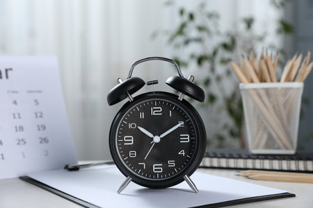 Deadline. Alarm clock, stationery and calendar on table indoorsの写真素材