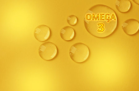 Drops of Omega-3 on yellow gradient background, top viewの写真素材